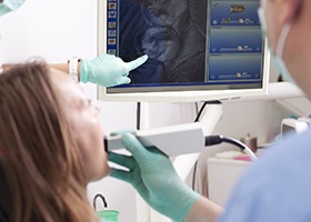 Woman and dentist looking at smile photos