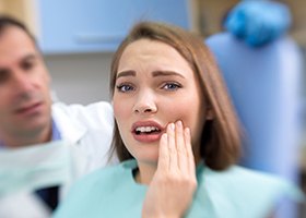 Woman holding cheek in pain