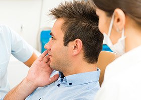 Man holding jaw in dental chair