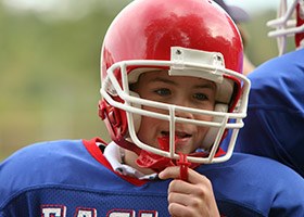 Young boy in football uniform with red mouthgurad
